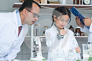 Asian scientist kid student and Indian teacher with plant at biology class in school laboratory, do an experiment, learning,