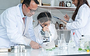 Asian scientist kid student and Indian teacher with plant at biology class in school laboratory, learning, teaching child girl to