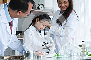 Asian scientist kid student and Indian teacher with plant at biology class in school laboratory, smiling, teaching child girl to