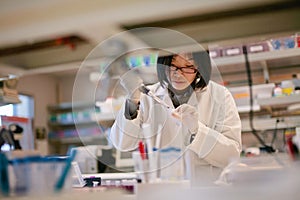 Asian Scientist Pipetting at a Biomedical Laboratory