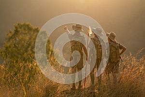 Asian scout leader stands and points out the long-distance targets for the scouts in the team for the next day`s journey near