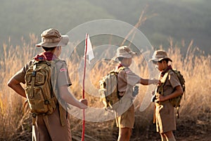 Asian Scout Leader watches as two Scouts in the team inspect each other`s attire before making the long journey to the Scout camp