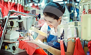 Asian seamstress in textile factory manufacturing apparel