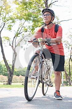 Asian Senior adult man riding bicycle in park