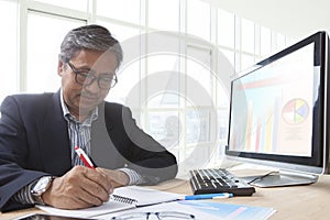 Asian senior business man working on computer table for office l