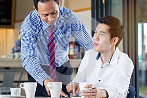 Asian senior businessman describe jobs to intern employee