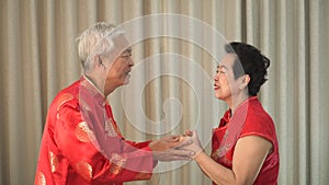 Asian senior couple celebrating Chinese New Year wearing red costume