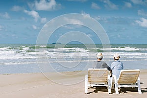 Asian senior couple or elderly people walking and siting at the beach