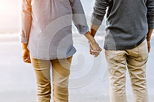 Asian senior couple or elderly people walking and siting at the beach