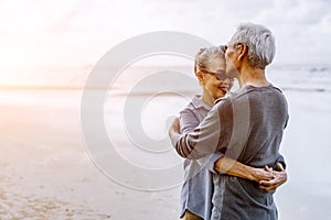 Asian senior couple or elderly people walking and siting at the beach