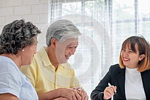 Asian senior couple with financial advisor about tax and retirement document at home.happy aging at home concept