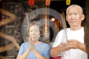 Senior couple praying buddha with incense stick