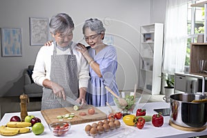 Asian senior couple preparing food in the kitchen. Retired people cooking meal at home