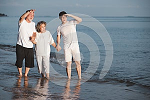Asian senior couple and son walking on summer beach sunset. Travel leisure and activity after retirement on vacations and summer