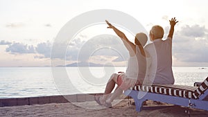 Asian senior couple standing playing at beach sunrise sea early morning relaxed happy natural retirement life