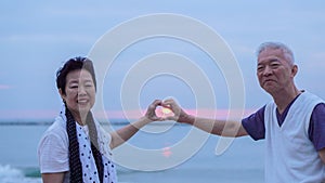 Asian senior couple together at sunrise beach. New year, new chapter concept