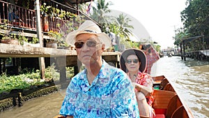 Asian senior couple travel to thailand cruising on the boat in f