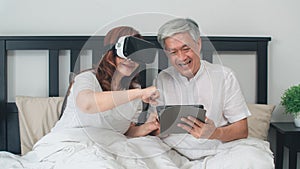 Asian senior couple using tablet at home. Asian Senior Chinese grandparents, feeling happy fun and VR playing games together while