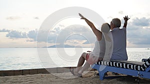Asian senior elder couple relax enjoy have fun on tropical seaside morning vacation retirement trip