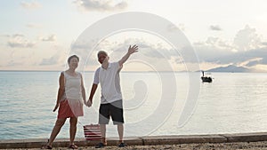 Asian senior elder couple relax enjoy have fun on tropical seaside morning vacation retirement trip