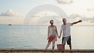 Asian senior elder couple relax enjoy have fun on tropical seaside morning vacation retirement trip