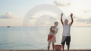 Asian senior elder couple relax enjoy have fun on tropical seaside morning vacation retirement trip