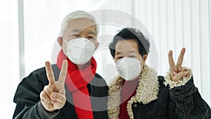 Asian senior elder couple send encourage for Covid-19 pandemic wearing mask