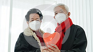 Asian senior elder couple send encourage for Covid-19 pandemic wearing mask