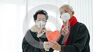 Asian senior elder couple send encourage for Covid-19 pandemic wearing mask
