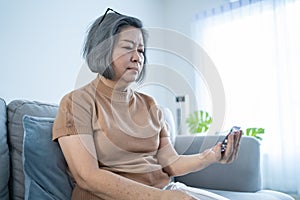 Asian Senior elder woman patient sit on wheelchair at nursing home care. Mature older female look to medicine pill bottle and read