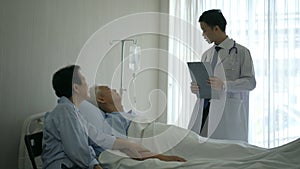 Asian senior elderly couple talking to doctor unwell health admit for cancer diagnose in hospital stress and worry expression