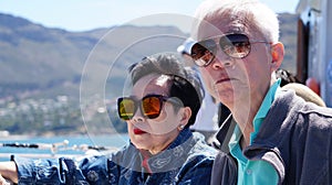 Asian senior elderly couple on tourist ferry boat to seals island trip attracion Fun wildlife watching aticity in South Africa