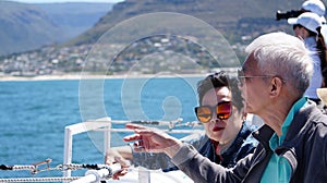 Asian senior elderly couple on tourist ferry boat to seals island trip attracion Fun wildlife watching aticity in South Africa