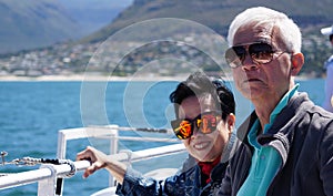 Asian senior elderly couple on tourist ferry boat to seals island trip attracion Fun wildlife watching aticity in South Africa