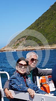 Asian senior elderly couple on tourist ferry boat to seals island trip attracion Fun wildlife watching aticity in South Africa