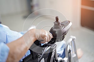 Asian senior or elderly old lady woman patient on electric wheelchair with remote control at nursing hospital ward
