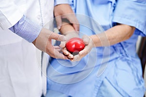Asian senior or elderly old lady woman patient holding red heart in her hand with doctor in nursing hospital