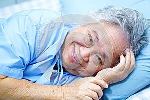 Asian senior or elderly old lady woman patient lying on bed in nursing hospital.