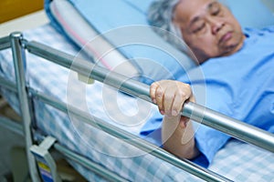 Asian senior or elderly old lady woman patient lying on bed in nursing hospital.