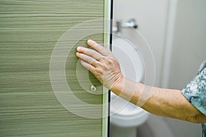 Asian senior elderly old lady woman patient open toilet bathroom slide door by hand