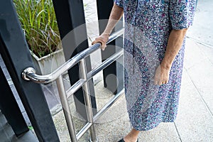 Asian senior or elderly old lady woman patient use slope walkway handle security with help support assistant in nursing hospital