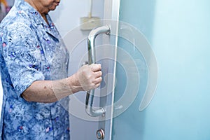 Asian senior or elderly old lady woman patient use toilet bathroom handle door security in nursing hospital ward