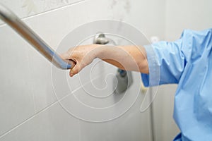 Asian senior or elderly old lady woman patient use toilet bathroom handle security in nursing hospital