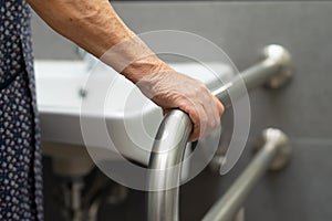 Asian senior or elderly old lady woman patient use toilet bathroom handle security in nursing hospital