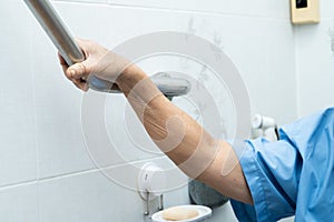 Asian senior or elderly old lady woman patient use toilet bathroom handle security in nursing hospital