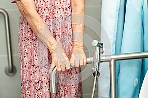 Asian senior or elderly old lady woman patient use toilet bathroom handle security in nursing hospital, healthy strong medical