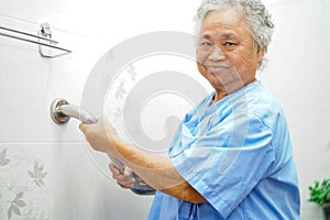 Asian senior or elderly old lady woman patient use toilet bathroom handle security in nursing hospital ward