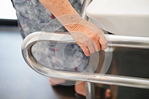 Asian senior or elderly old lady woman patient use toilet bathroom handle security in nursing hospital ward