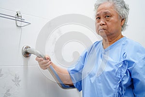 Asian senior or elderly old lady woman patient use toilet handle security in nursing hospital.