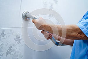 Asian senior or elderly old lady woman patient use toilet handle security in nursing hospital.